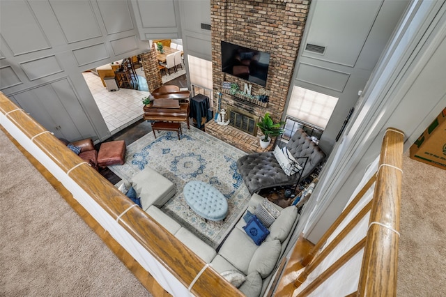 carpeted living room with a brick fireplace