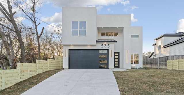 contemporary home with a front lawn and a garage