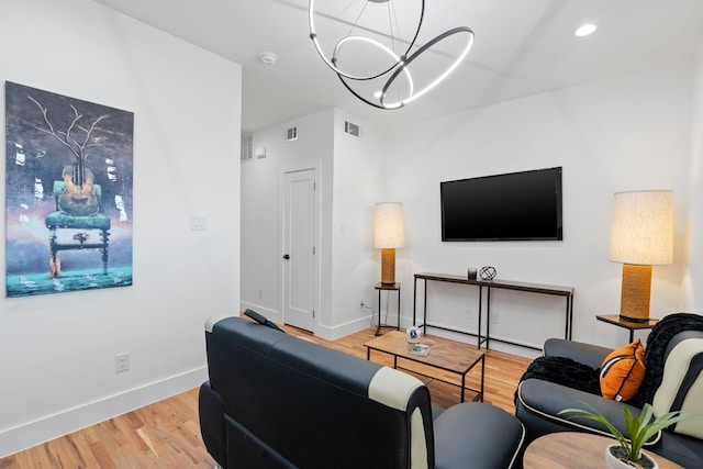 living room featuring light hardwood / wood-style floors and an inviting chandelier