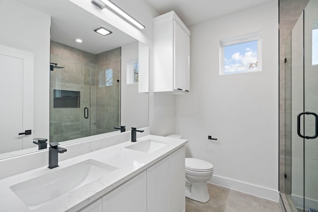 bathroom with tile patterned floors, a shower with door, vanity, and toilet