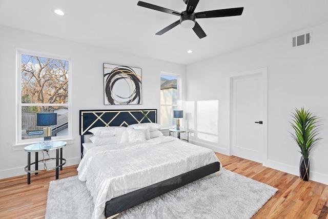 bedroom with multiple windows, light wood-type flooring, and ceiling fan