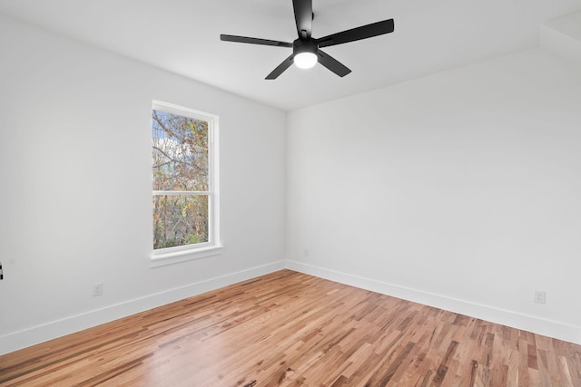 spare room featuring ceiling fan, wood-type flooring, and a wealth of natural light