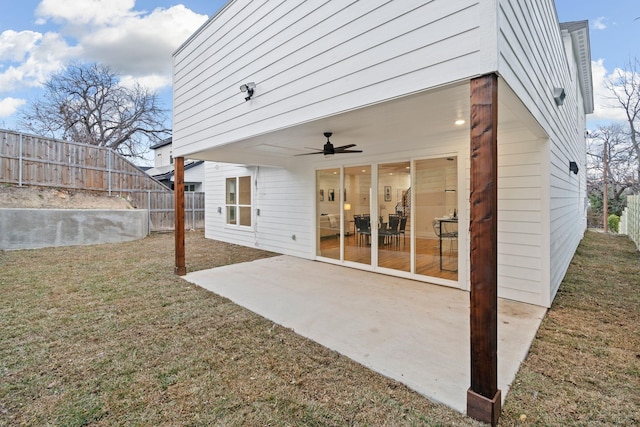 rear view of property with a lawn, ceiling fan, and a patio