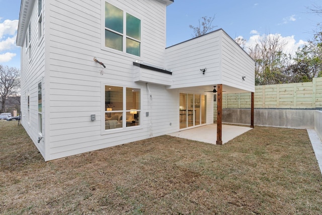 rear view of house featuring a patio and a lawn