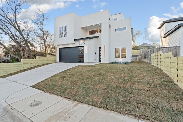 view of front of property with a garage and a front lawn