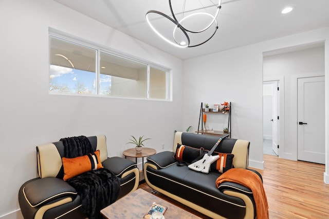 living room with light hardwood / wood-style flooring and a notable chandelier