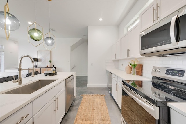 kitchen with white cabinets, hanging light fixtures, sink, and appliances with stainless steel finishes