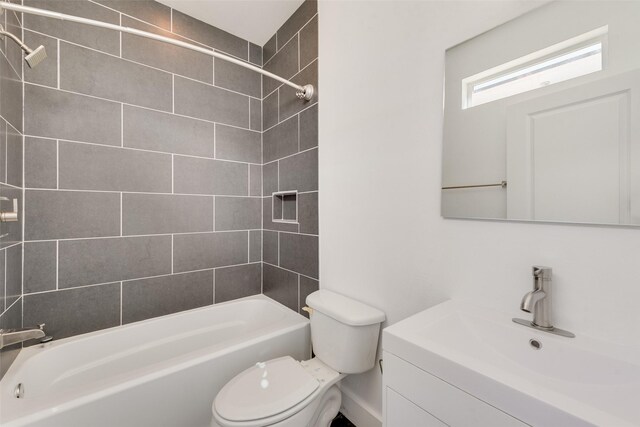 full bathroom featuring vanity, tiled shower / bath combo, and toilet