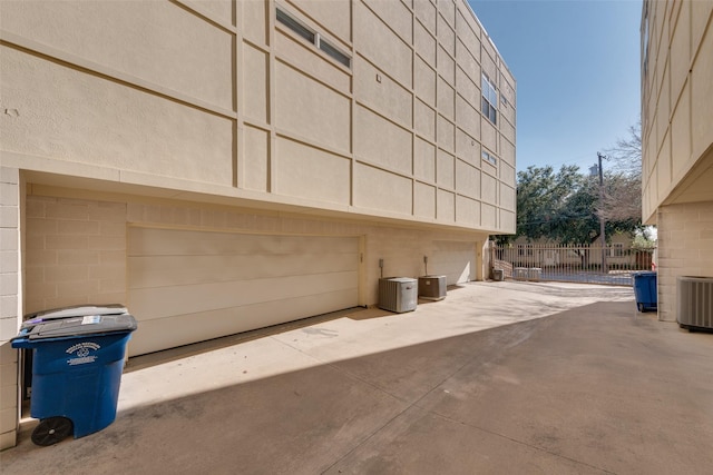 view of side of home with a garage and central AC unit