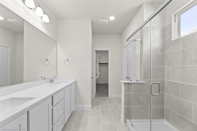 bathroom with tile patterned flooring, vanity, and a shower with door