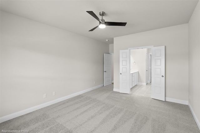 unfurnished bedroom featuring ceiling fan, light colored carpet, and ensuite bathroom