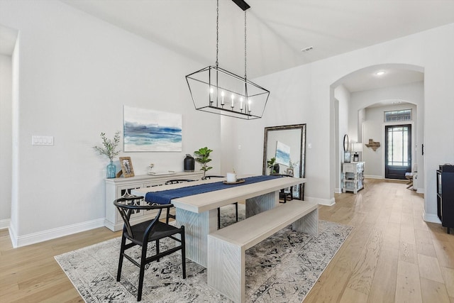 dining space featuring light hardwood / wood-style flooring and an inviting chandelier