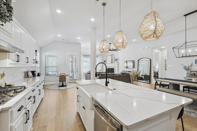 kitchen featuring a spacious island, white cabinetry, stainless steel appliances, and decorative light fixtures