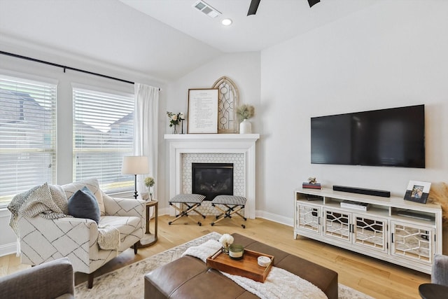 living room with a fireplace, wood-type flooring, vaulted ceiling, and ceiling fan