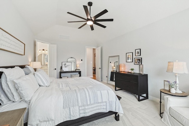 bedroom featuring lofted ceiling, light carpet, ceiling fan, connected bathroom, and a tray ceiling