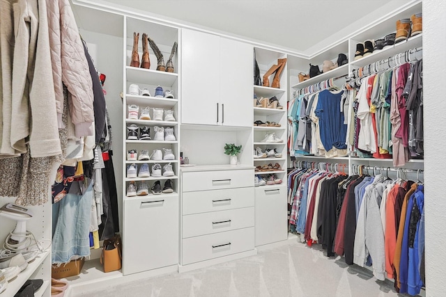 walk in closet featuring light carpet