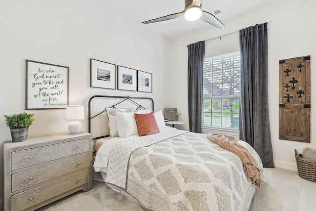 bedroom with ceiling fan, light carpet, and multiple windows