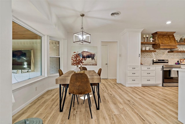 dining room with a chandelier and light hardwood / wood-style flooring