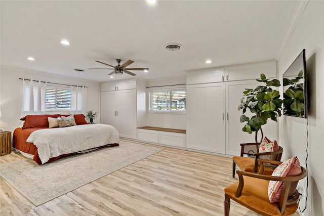 bedroom with ornamental molding, ceiling fan, and light hardwood / wood-style floors