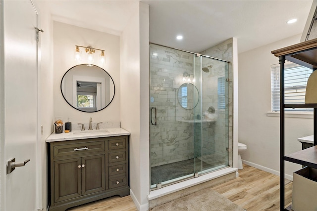 bathroom with walk in shower, wood-type flooring, and vanity