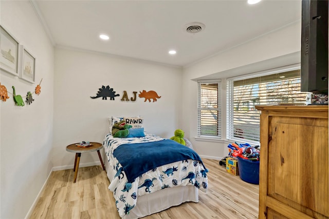 bedroom featuring light hardwood / wood-style flooring and ornamental molding