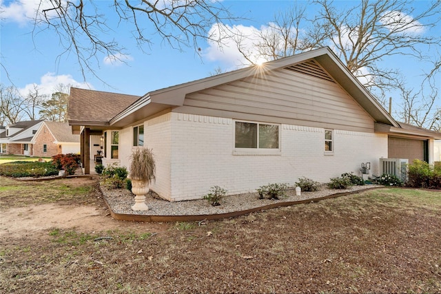 view of property exterior featuring a garage and central air condition unit