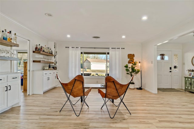 dining space featuring crown molding, a wealth of natural light, and light hardwood / wood-style floors