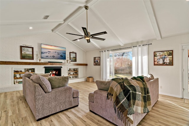 living room with lofted ceiling with beams, ceiling fan, a fireplace, and light hardwood / wood-style flooring