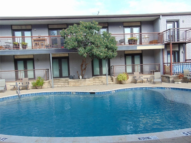 view of swimming pool featuring french doors