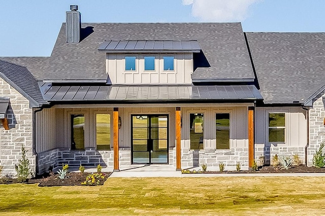 rear view of property featuring covered porch and a lawn