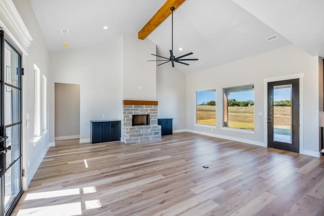 unfurnished living room with ceiling fan, light hardwood / wood-style flooring, beamed ceiling, high vaulted ceiling, and a fireplace