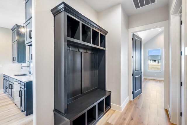 mudroom featuring sink, lofted ceiling, and light hardwood / wood-style flooring