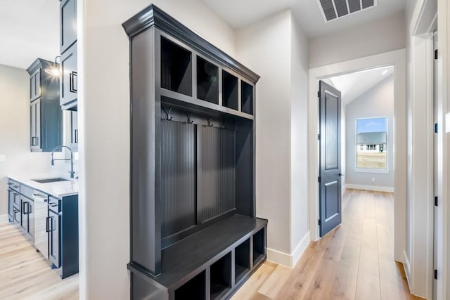 mudroom featuring lofted ceiling, sink, and light hardwood / wood-style flooring