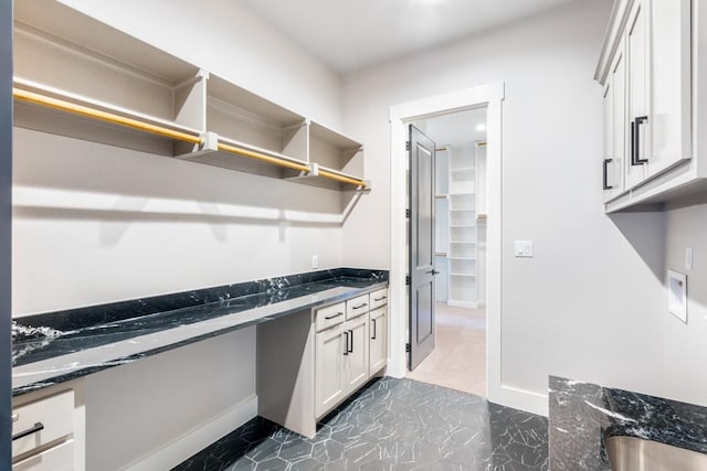 clothes washing area with cabinets