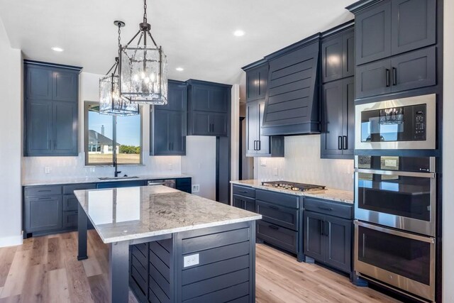 kitchen with light wood-type flooring, a center island, stainless steel appliances, and custom exhaust hood