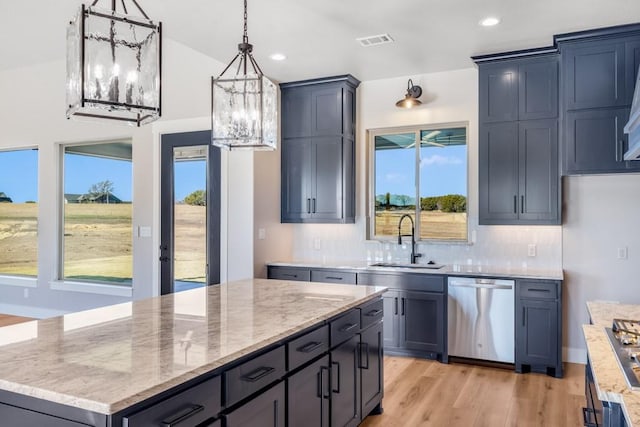 kitchen with pendant lighting, dishwasher, sink, light hardwood / wood-style flooring, and a kitchen island