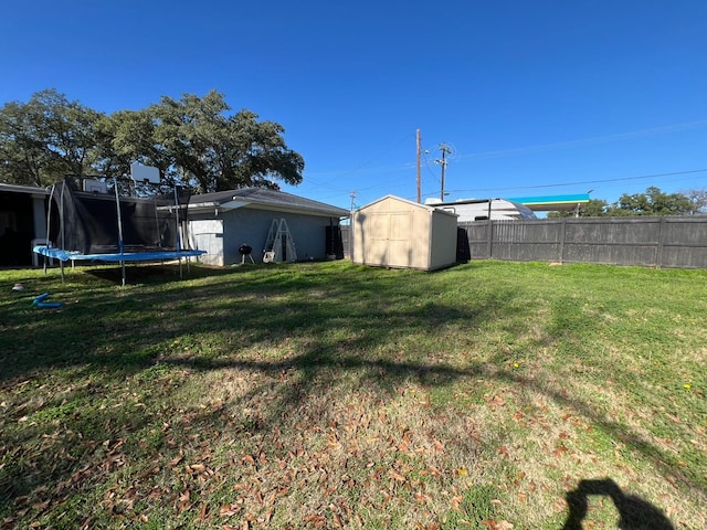 view of yard with a trampoline and a shed