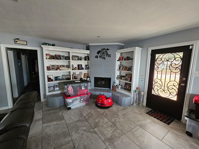 living room with a textured ceiling and a fireplace