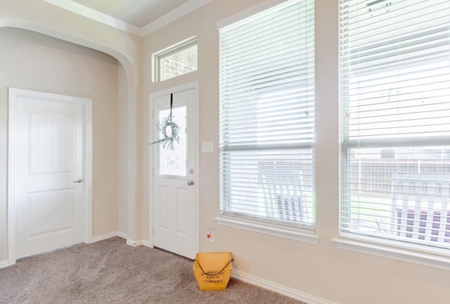 carpeted foyer with ornamental molding