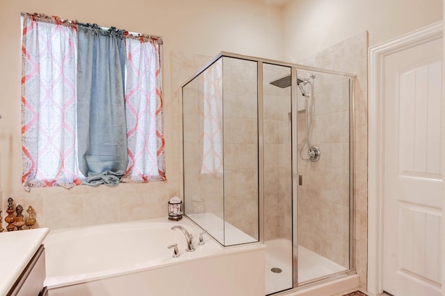 bathroom featuring shower with separate bathtub and vanity