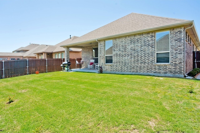 back of property with a yard and a patio area