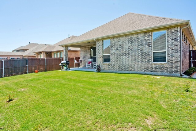 rear view of house featuring a patio area and a yard