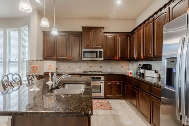 kitchen featuring backsplash, appliances with stainless steel finishes, sink, and dark stone counters