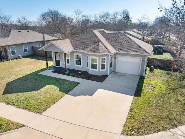 single story home with a front lawn, an attached garage, fence, and driveway