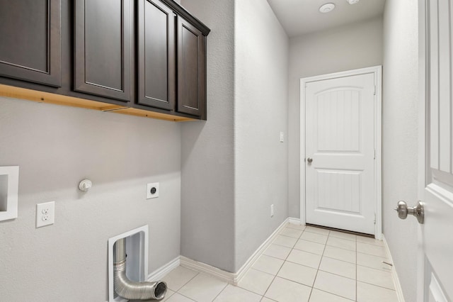 laundry area featuring hookup for an electric dryer, light tile patterned floors, hookup for a gas dryer, and cabinets