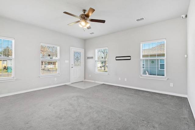 carpeted empty room featuring plenty of natural light and ceiling fan