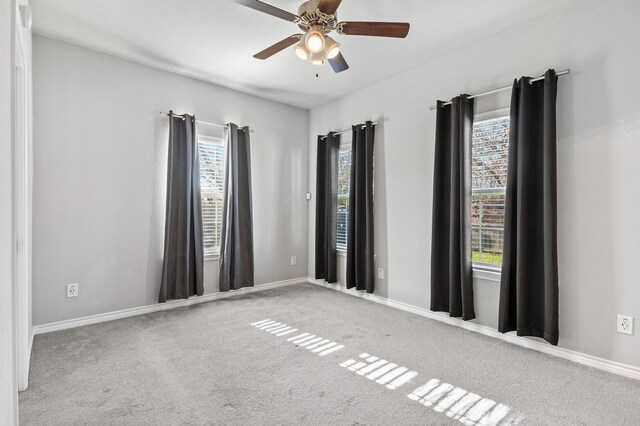 empty room with ceiling fan and carpet floors