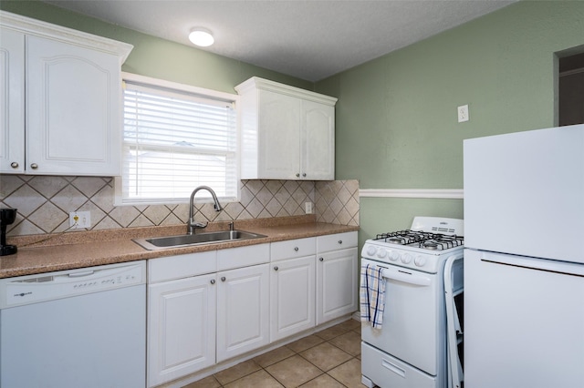 kitchen featuring sink, white appliances, white cabinetry, light tile patterned flooring, and decorative backsplash