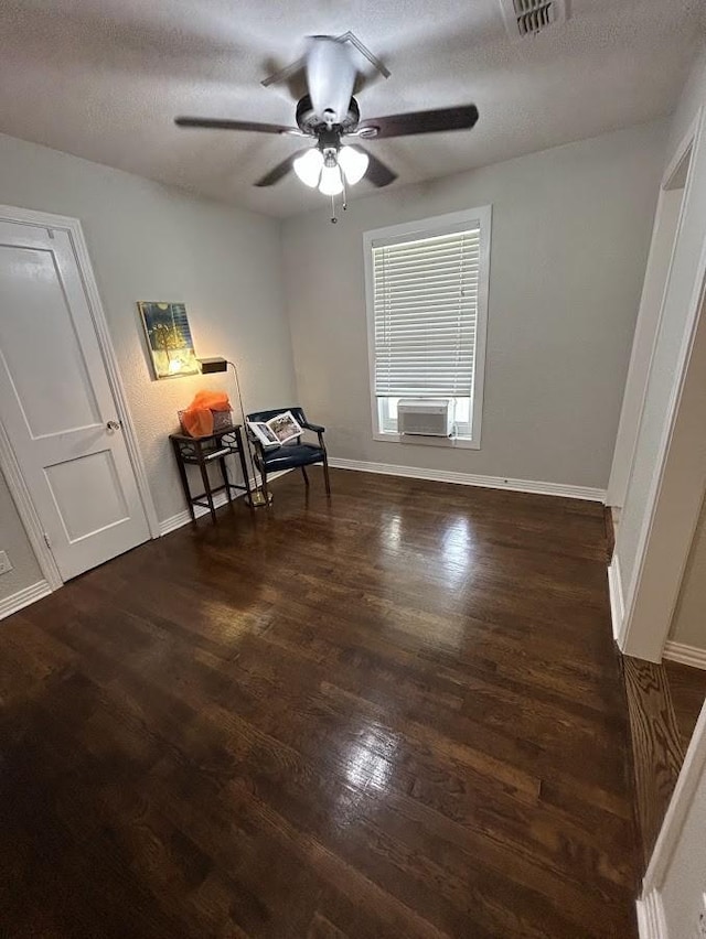 unfurnished room with visible vents, baseboards, ceiling fan, wood finished floors, and a textured ceiling