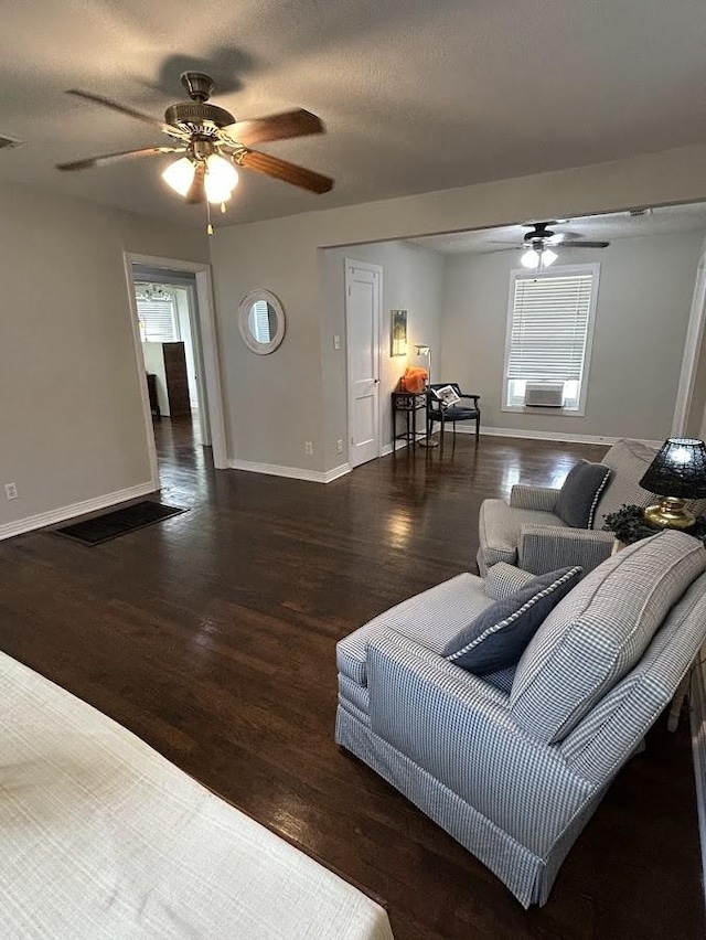 living room with baseboards, a textured ceiling, wood finished floors, and a ceiling fan